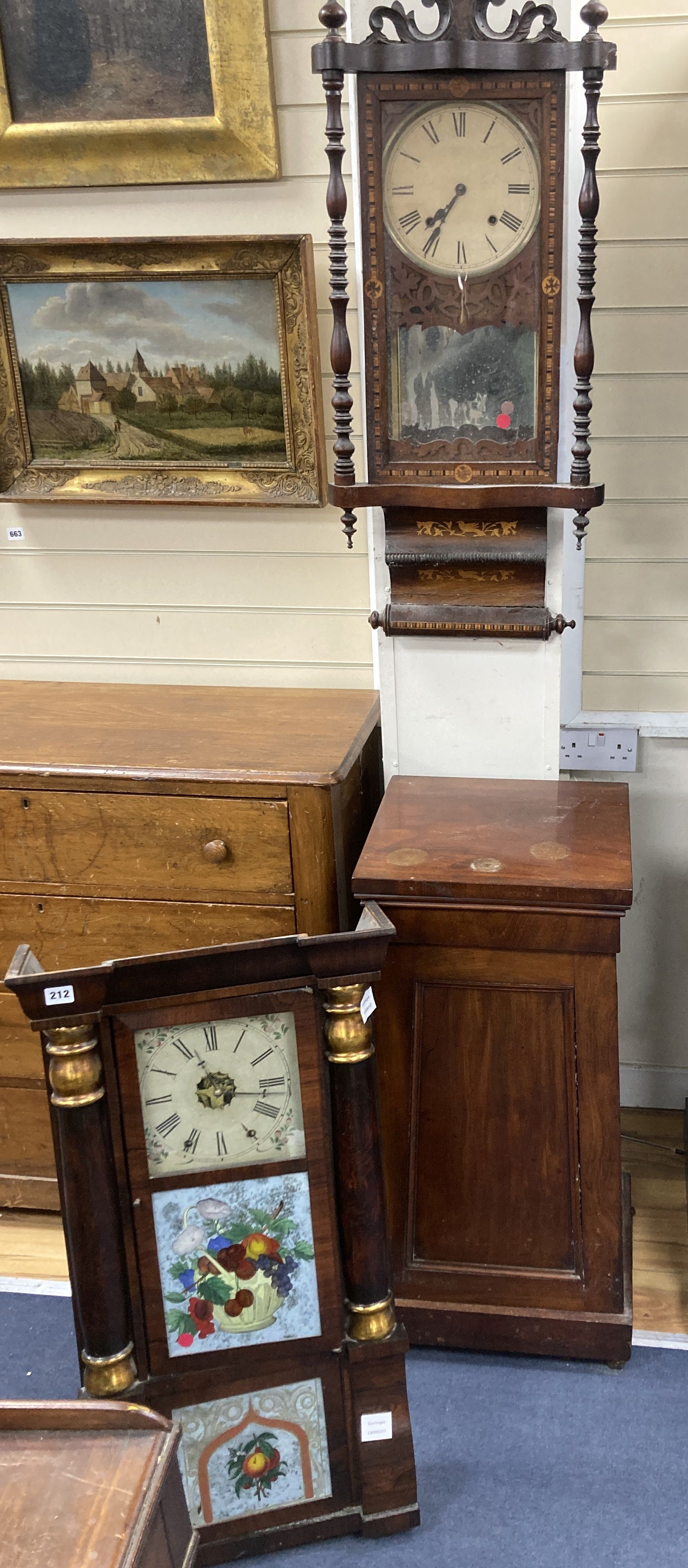 A 19th century American simulated rosewood wall clock, height 84cm, a 19th century inlaid wall clock and a mahogany pedestal cupboard